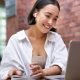 young-smiling-asian-woman-with-wireless-earphones-sitting-in-coworking-office-space-with-laptop.jpg